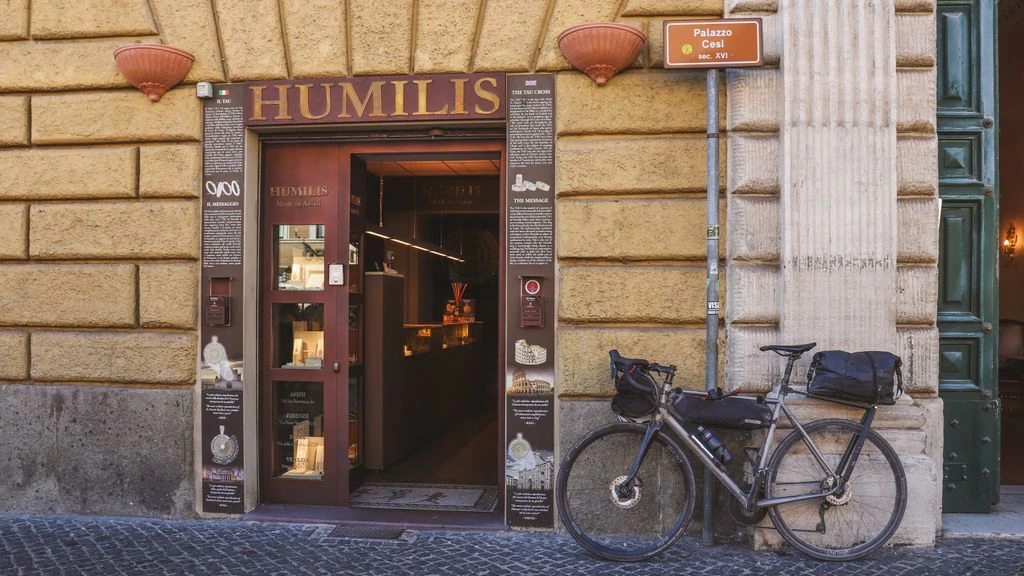 The lit stone entrance of Hotel Coppedè at dusk